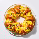 This egg and ham bake is a savory wreath with melted cheese, promising a comforting taste.