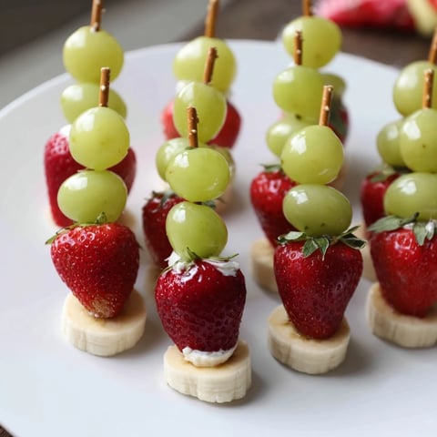 Festliche Elf-Hut Erdbeer-Spieße: fruchtige Erdbeeren, Bananen und Trauben, perfekt für Partys.