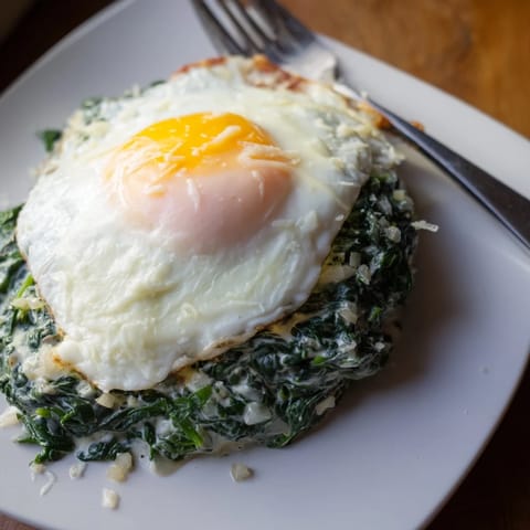 Eine köstliche Kombination aus cremediem Spinat und einem goldenen Spiegelei.  