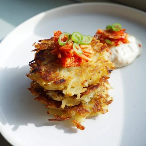 Enjoy crispy Kartoffelpuffer, perfectly fried, served with cooling, spicy kimchi yogurt.