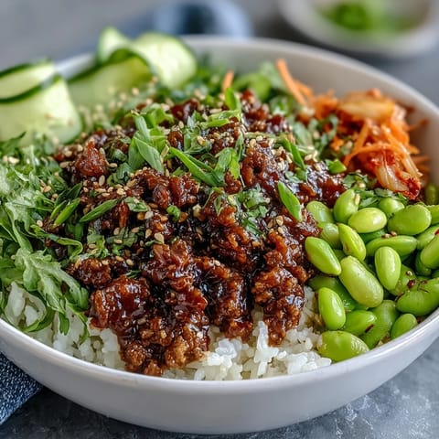 Steaming Korean Ground Beef Bowl mit gekochtem Reis, scharfem Gochujang-Rindfleisch und buntem Gemüse.