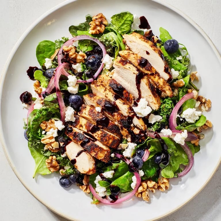 Fresh blueberry goat cheese chicken salad with walnuts and balsamic glaze drizzled over the greens.